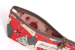 Detail eines roten Mäppchens mit Illustrationen, Bärenanhänger und Innenfutter