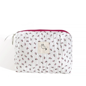 Quilted floral makeup bag with pink zipper and alpaca patch on clean white background