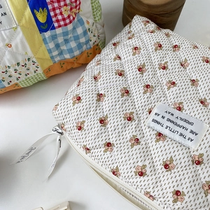 Detail of quilted cotton makeup bags with floral patterns and Just for you ribbon zippers