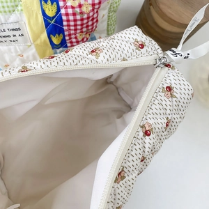 Close-up of quilted floral cosmetic bag showing interior lining and zipper detail