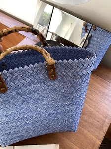Detail der blau geflochtenen Tragetasche mit natürlichen Bambusgriffen und Webstruktur