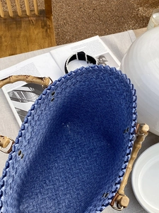 Detailansicht der geflochtenen Tasche mit Bambusgriffen zeigt Textur und Innenraum