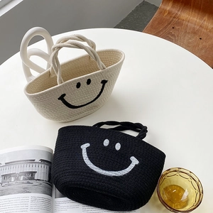 Detail shot of woven cotton rope bags in black and white with cute smiley face patterns