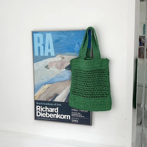 Detalle de bolsa de playa de ganchillo verde con diseño de malla calada y tejido denso