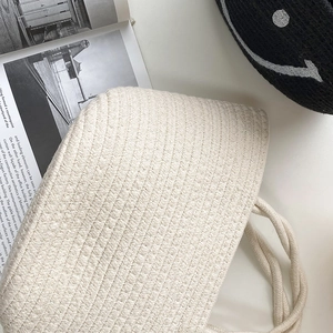 Detail shot of cream woven cotton rope bag featuring diamond pattern texture and soft handle