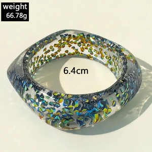 Detail eines klobigen lila Harzarmbands mit holografischem Glitter und Schliff