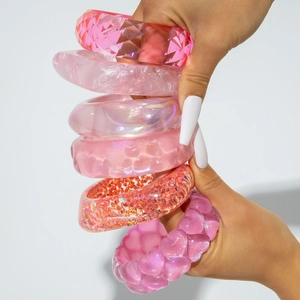 Pink resin bangle set with glitter, marble texture, and heart patterns on white background