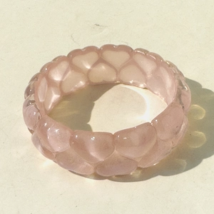 Detailed view of pink translucent resin ring featuring connected 3D heart shapes