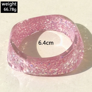 Top view of pink resin bangle showing aurora glitter sequins and weight measurement