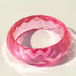 Macro view of pink translucent resin bracelet with faceted diamond-cut texture