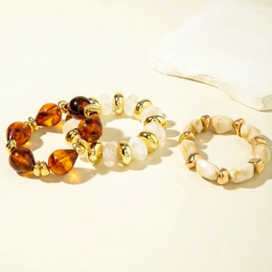 Detail of vintage acrylic beaded bracelets with amber resin drops and marble texture