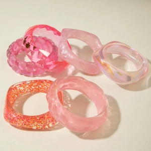 Close-up of pink resin bangles featuring marble patterns and glitter details