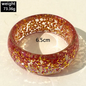 Detailed view of resin bangle with gold glitter foil showing 6.5cm inner diameter and weight