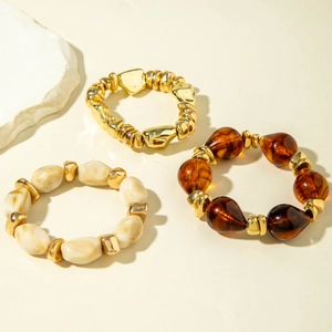 Three-piece stackable beaded bracelet set with gold pebbles and marble resin beads