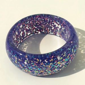 Macro detail of cobalt blue resin bangle featuring sparkling multicolored holographic flakes