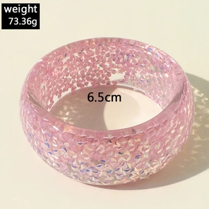 Detail view of pink resin bangle with glitter texture showing weight and diameter