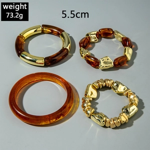 Close-up of a 4-piece chunky amber resin and gold metal bead stretch bracelet set