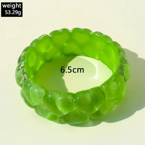 Macro shot of a translucent green resin bangle with embossed texture, 6.5cm inner diameter