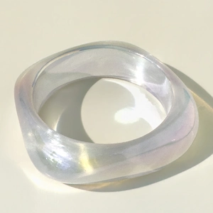 Close-up of chunky resin bracelet featuring iridescent laser finish and wavy geometric shape
