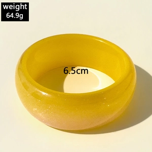 Détail du bracelet en résine jaune translucide à paillettes, diamètre 6,5cm et poids 64,9g
