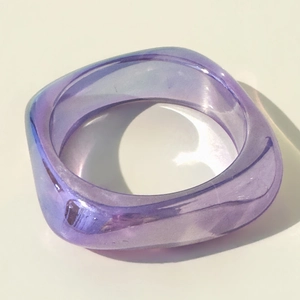 Macro shot of purple translucent resin square bangle with laser iridescent finish