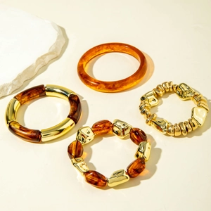 Detail of vintage matte gold and amber acrylic beaded bracelet set on stone decor