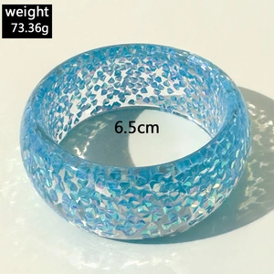 Detailed close-up of light blue resin bangle with rainbow glitter flakes and 6.5cm diameter