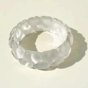 Macro view of transparent chunky resin ring with bubble wave design and glossy texture