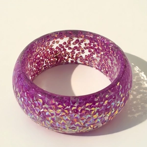 Macro detail of purple resin bangle with holographic glitter flakes and glossy finish
