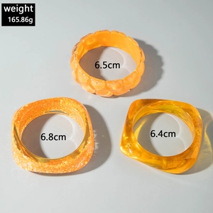 Detailed view of orange resin bangles set showing weights and inner diameters