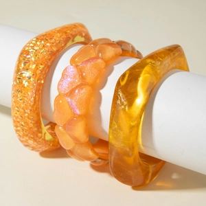 Three-piece set of translucent amber resin bangles with glitter and geometric designs