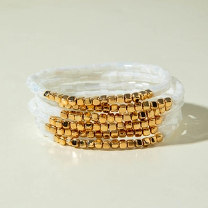 Mehrlagiges Bohème-Armband-Set mit weißen Perlen und goldfarbenen Metallakzenten
