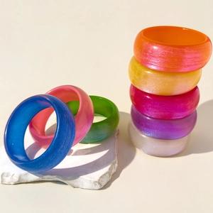 Bracelets en résine pailletée en 8 couleurs vives présentés sur une base en pierre