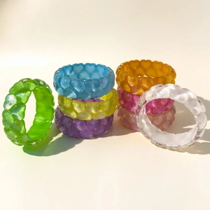 Colorful resin heart rings with glitter texture and woven pattern in various vibrant shades