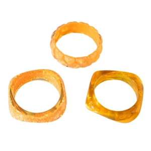 Three-piece chunky resin ring set in amber orange with heart texture and gold flakes