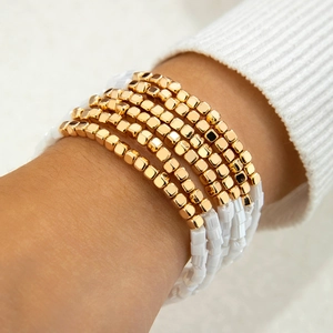 Set aus fünf gold-weißen Perlenarmbändern im minimalistischen Bohemian-Stil