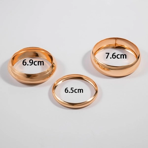 Detailed view of three polished gold bangles with size markings of 6.5cm, 6.9cm, and 7.6cm