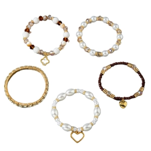 Fünfteiliges böhmisches Perlenarmband-Set mit Herzanhängern und weißen Perlen auf Weiß