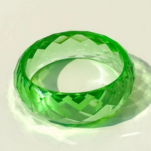 Détail du bracelet en résine verte facettée avec finition laser à paillettes