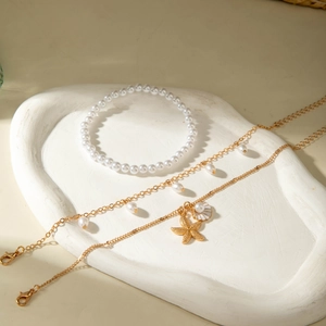 Set de tobilleras bohemias con perlas y colgante de estrella de mar en base blanca