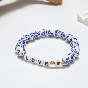 Close-up of blue floral porcelain beads and LOVE lettering beads on a beaded bracelet