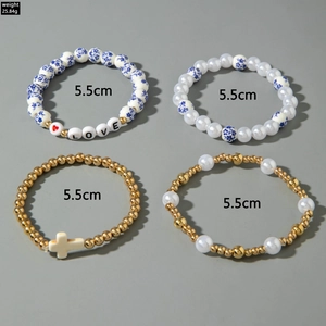Detail of four retro style ceramic and gold beaded elastic bracelets with cross charms
