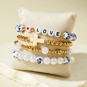Detail of four-piece beaded bracelet set with floral ceramic beads and LOVE lettering