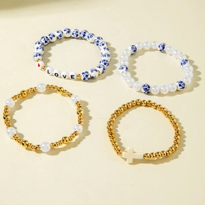 Detail of four bohemian beaded bracelets with porcelain beads, pearls and cross pendant