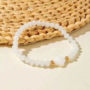 Detail of colorful crystal beaded bracelet featuring white clover charm and gold accents