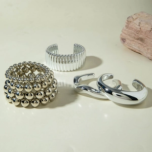 Three-piece silver bead bracelet and chunky metallic bangles set with mirror finish
