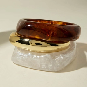 Three-piece chunky resin and gold metal stacked bracelets set in amber and pearl white