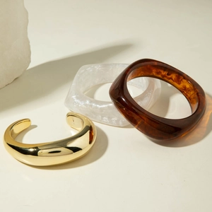 Detailed set of resin and gold metal bracelets showing marble and amber textures