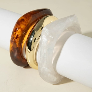 Three-piece set of wide resin bangle bracelets with gold metal and marbled textures