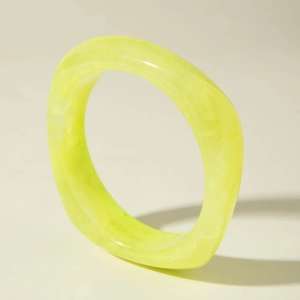 Détail du bracelet épais en résine néon avec une texture artistique nacrée et nuageuse